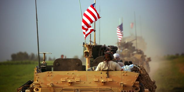 US forces, accompanied by Kurdish People's Protection Units (YPG) fighters, drive their armoured vehicles near the northern Syrian village of Darbasiyah, on the border with Turkey on April 28, 2017. / AFP PHOTO / DELIL SOULEIMAN (Photo credit should read DELIL SOULEIMAN/AFP/Getty Images)