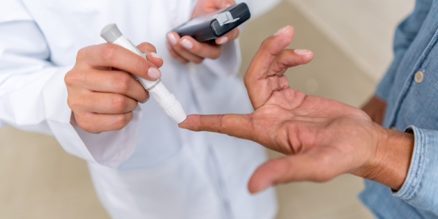 Man checking sugar level with glucometer using a blood sample