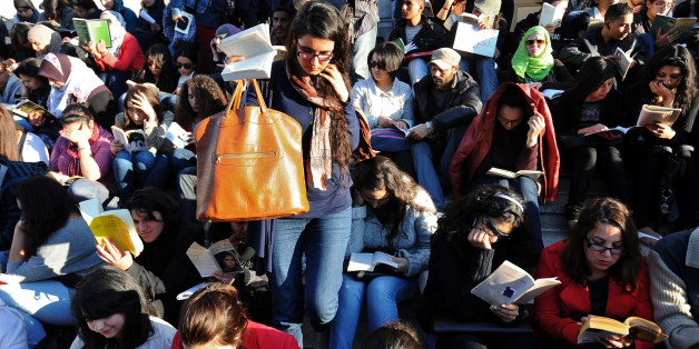 Tunisians, many of them reading a book, sit in the Avenue Habib Bourguiba for a day of reading on April 18, 2012 or other places like cafes or park of Tunis. Tunisian people want to show to governement by reading in many places of the city that without demonstrating or demanding something they can change the world, as organizers said that 'those who will change the world are those who read.' AFP PHOTO/ FETHI BELAID (Photo credit should read FETHI BELAID/AFP/Getty Images)