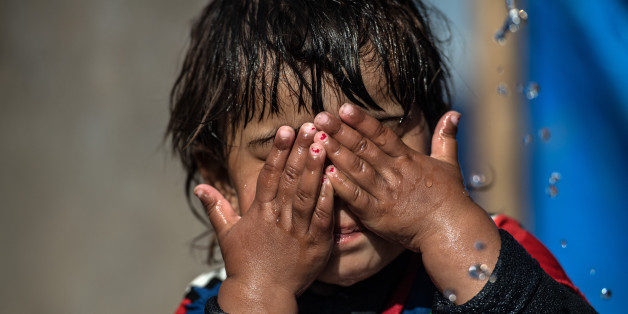 MOSUL, IRAQ - APRIL 15: A little girl washes her face under a tap in Khazir refugee camp on April 15, 2017 near Mosul, Iraq. Khazir camp, with a capacity of roughly 30,000 and along with several other camps near the city of Mosul, provides home for the approximately 300,000 people who have fled Iraq's second largest city as Iraqi government forces continue the military campaign to recapture the city from Islamic State who captured it in 2014. (Photo by Carl Court/Getty Images)