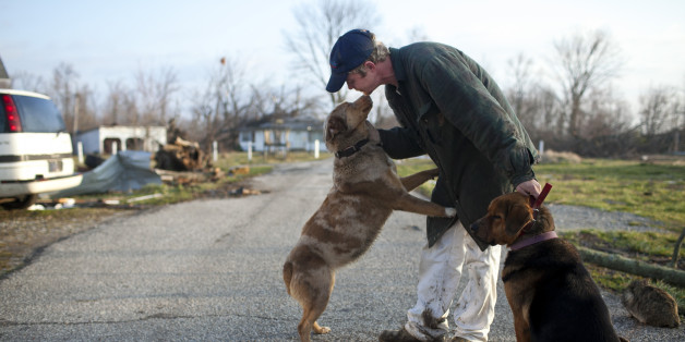 Mike Franke reunites with his dog in Marysville, Indiana March 3, 2012. The latest in a series of powerful tornadoes raked across a broad swath of the U.S. Midwest and Southeast, killing at least 33 people in four states, authorities said on Saturday. The fast-moving twisters on Friday splintered homes, damaged a prison and tossed around vehicles across the region, leaving 14 dead in Indiana, officials said. REUTERS/Aaron Bernstein (United States - Tags: ENVIRONMENT DISASTER)
