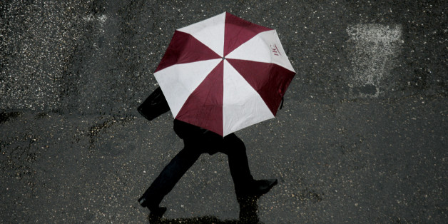 A woman crosses a road, during a long expected rainfall, in central Athens March 22, 2007. Greece has been experiencing one of the driest winters in 20 years with the month of January recording the lowest rainfall levels in half a century. REUTERS/Yannis Behrakis (GREECE)