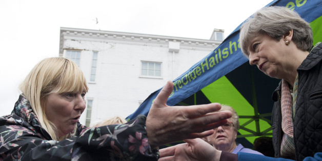 British Prime Minister, and leader of the Conservative party, Theresa May (R) reacts as she talks with a shopper during an election campaign walk about around Abingdon Market near Oxford, north-west of London, on May 15, 2017.Britain goes to the polls on June 8 to elect a new parliament in a general election. / AFP PHOTO / POOL / Justin TALLIS (Photo credit should read JUSTIN TALLIS/AFP/Getty Images)