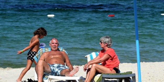British tourists sit in the sun on July 10, 2015 in the Mouradi Hotel in the touristic Port el Kantaoui, on the outskirts of Sousse south of the capital Tunis. Denmark followed Britain's example in urging its nationals to cut short their holidays in Tunisia after London warned the country was still unsafe after last month's beach massacre. AFP PHOTO / FETHI BELAID (Photo credit should read FETHI BELAID/AFP/Getty Images)