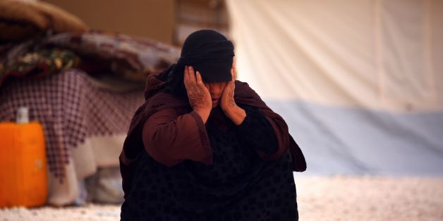 A displaced Syrian woman who fled the Islamic State (IS) group stronghold of Raqa sits at a temporary camp in the northern Syrian village of Ain Issa on May 19, 2017. / AFP PHOTO / DELIL SOULEIMAN (Photo credit should read DELIL SOULEIMAN/AFP/Getty Images)