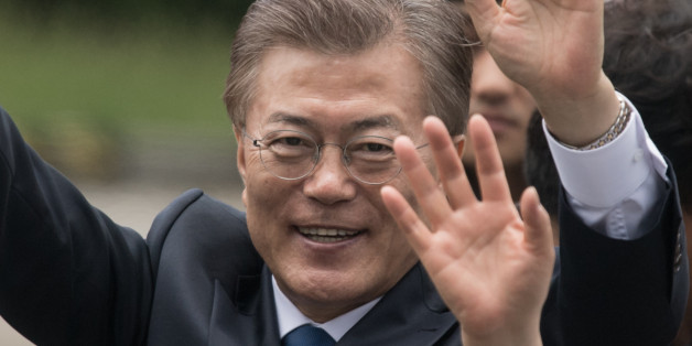 South Korea's President Moon Jae-In waves to his supporters as he greets members of staff as he arrives near the presidential Blue House in Seoul on May 10, 2017.Left-leaning former human rights lawyer Moon Jae-In began his five-year term as president of South Korea following a landslide election win after a corruption scandal felled the country's last leader. / AFP PHOTO / Ed JONES (Photo credit should read ED JONES/AFP/Getty Images)