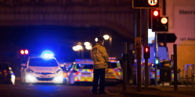 Police vehicles and a police officer are seen outside the Manchester Arena, where U.S. singer Ariana Grande had been performing in Manchester, northern England, Britain May 22, 2017. REUTERS/Jon Super