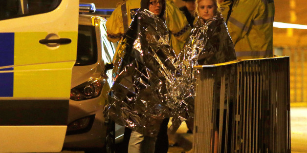 Two women wrapped in thermal blankets stand near the Manchester Arena, where U.S. singer Ariana Grande had been performing, in Manchester, northern England, Britain, May 23, 2017. REUTERS/Andrew Yates