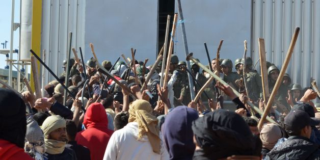 Tunisian protesters comfront security forces outside the El Kamour oil and gas pumping station, in the southern state of Tataouine, on May 22, 2017, during a sit-in to demand a share of local resources and priority for jobs in the sector.
A young protester was killed after a national guard vehicle 'accidentally' ran him over in the desert installation, raising fears of mounting social unrest in a region rocked by weeks of protest. / AFP PHOTO / FATHI NASRI (Photo credit should read FATHI NASRI/AFP/Getty Images)
