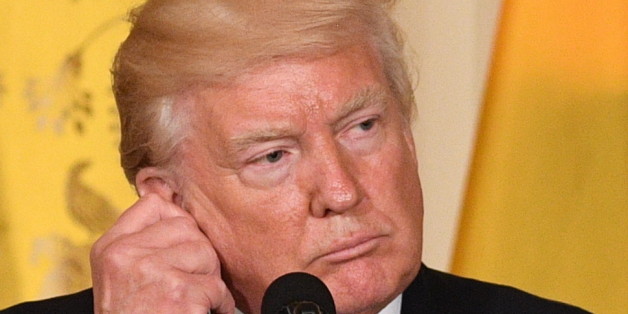 US President Donald Trump adjusts his translation ear piece during a joint press conference with Colombia's President Juan Manuel Santos at the White House on May 18, 2017 in Washington, DC. / AFP PHOTO / JIM WATSON (Photo credit should read JIM WATSON/AFP/Getty Images)