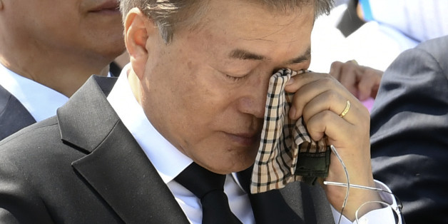 South Korean President Moon Jae-in wipes a tear from his eyes during the annual Democratic uprising memorial at the Gwangju National Cemetery, in the southwestern city of Gwangju on May 2017, as the government holds an annual ceremony to mark the 37th anniversary of a pro-democracy uprising. Moon commemorated the anniversary of the 1980 pro-democracy uprising in the city of Gwangju where hundreds of protestors were killed by the military. / AFP PHOTO / POOL / Kim Min-Hee (Photo credit sho