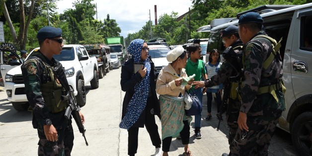 Philippine policemen check evacuees from Marawi aboard a van at a checkpoint by the entrance of Iligan City, in southern island of Mindanao on May 24, 2017.
Philippine President Rodrigo Duterte warned that martial law would be 'harsh' and like a dictatorship, after imposing military rule in the south of the country to combat Islamist militants. / AFP PHOTO / TED ALJIBE (Photo credit should read TED ALJIBE/AFP/Getty Images)