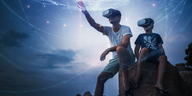 Father and son using Virtual Reality glasses sitting outside. Stock Photo. Creative Content Brief 603438805