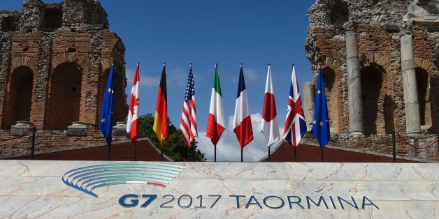 A picture shows flags on the stage of the ancient Greek Theater where Heads of State and of Government of the G7, the group of most industrialized economies, will pose for a family picture, on May 26, 2017 in Taormina, Sicily.The leaders of Britain, Canada, France, Germany, Japan, the US and Italy will be joined by representatives of the European Union and the International Monetary Fund (IMF) as well as teams from Ethiopia, Kenya, Niger, Nigeria and Tunisia during the summit from May 26 to 27,