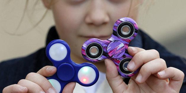PARIS, FRANCE - MAY 20: In this photo illustration, a child shows a 'Hand Spinner' on May 20, 2017 in Paris, France. The 'Hand Spinner' is a toy that sits like a propeller on a person's finger, with blades that spin around a bearing. Since a month the 'Hand spinner' or 'Fidget spinner', a whirligig from the United States has become a mondial phenomenon to the point of creating stock shortages in toy stores. (Photo Illustration by Chesnot/Getty Images)