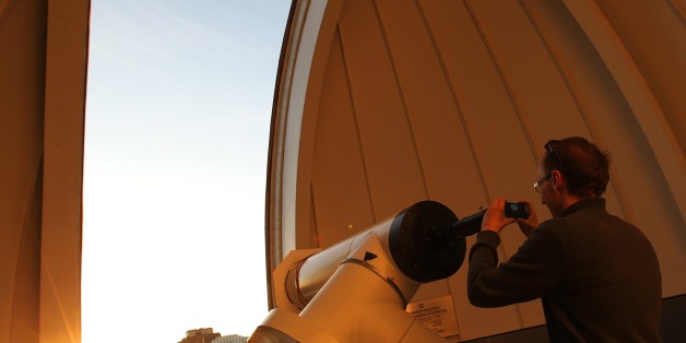 A man takes a picture through a telescope of Venus transiting across the Sun at the Vienna Urania observatory in Vienna on June 6, 2012. Sky-gazers around the world held up their telescopes and viewing glasses on June 6 to watch Venus slide across the sun -- a rare celestial phenomenon that will not happen again for more than 100 years. The spectacle began shortly after 2200 GMT on June 5 in parts of North America, Central America and the northern part of South America, and was seen, with magnif