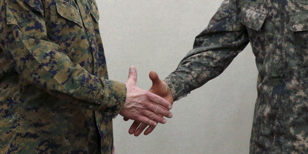 South Korean defense ministry's Director General Major General Jang Kyung-soo shakes hands with U.S. Forces Korea's Major General Robert Hedelund (L) during their working-level talk to discuss the potential deployment of a THAAD missile defense system at the Defense Ministry in Seoul, South Korea, March 4, 2016. REUTERS/Kim Hong-Ji