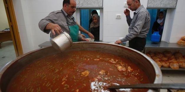 Volunteers distribute food to poor families at a soup kitchen run by the Islamic Waqf in the old city of the West Bank town of Hebron on June 1, 2017, during the Muslim holy fasting month of Ramadan. / AFP PHOTO / HAZEM BADER (Photo credit should read HAZEM BADER/AFP/Getty Images)