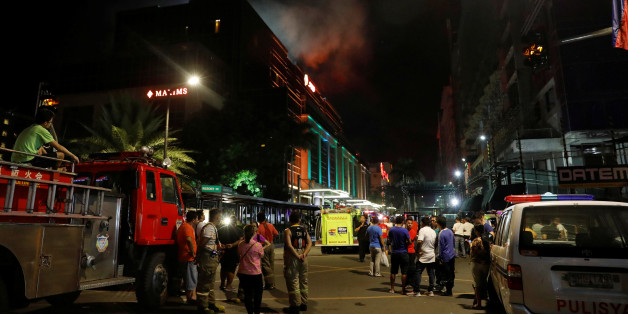 Evacuated employees and guests of hotels stand along a road and watch as smoke billows from a Resorts World building in Pasay City, Metro Manila, Philippines June 2, 2017. REUTERS/Erik De Castro TPX IMAGES OF THE DAY