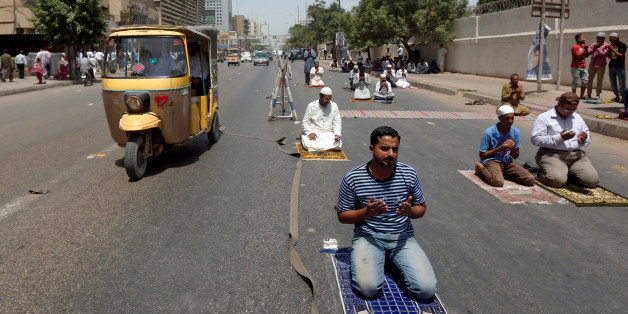Men hold their palms together after Friday prayers along a road during the Muslim holy month of Ramadan in Karachi, Pakistan June 2, 2017. REUTERS/Akhtar Soomro
