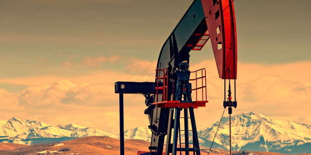 Oil and gas pump jack against mountains, at dusk. Lots of copy space. (Please see my portfolio for related photos and video clips).