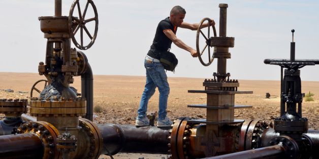 A local turns the wheel of a petroleum pumping station in El Kamour, in Tunisia's southern state of Tatatouine, on May 24, 2017, as protestors continue to stage a sit-in outside the oil and gas plant to demand for a share of the resources and employment in the sector. Since April 23, 2017, hundreds of protesters have blocked traffic on the road leading to the oilfields in Tataouine and erected tents at a sit-in outside el-Kamour, demanding the allocation of 70 percent of jobs in the petroleum se
