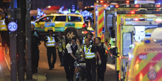 Police officers and members of the emergency services attend to a person injured in an apparent terror attack on London Bridge in central London on June 3, 2017.Armed police fired shots after reports of stabbings and a van hitting pedestrians on London Bridge on Saturday in an incident reminiscent of a terror attack in March just days ahead of a general election. / AFP PHOTO / DANIEL SORABJI (Photo credit should read DANIEL SORABJI/AFP/Getty Images)