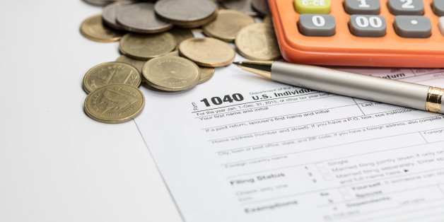 US tax form with pen and coins selective focus / taxation concept