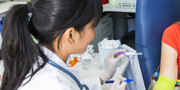 Drawing blood...young doctor prepairing for blood capture from a vein for laboratory analyses from cute young woman