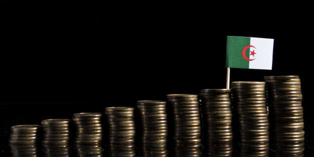 Algerian flag with lot of coins isolated on black background