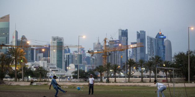 DOHA, QATAR - APRIL 09: Migrant workers play football on an area of wasteland beneath the sky scrapers of Doha's West Bank on April 09, 2016 in Doha, Qatar. (Photo by Charlie Crowhurst/Getty Images)