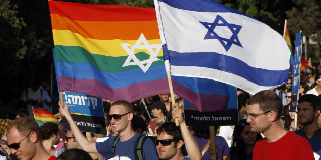 Participants hold flags during the gay pride parade in Jerusalem July 29, 2010. This year's parade marks the one-year anniversary of a shooting attack in a gay and lesbian youth center in Tel Aviv, in which two people were killed and 13 were injured. REUTERS/Ronen Zvulun (JERUSALEM - Tags: POLITICS SOCIETY)