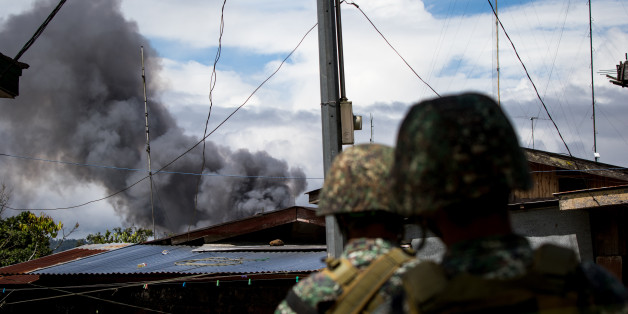 Philippine marines look at smoke following an airstrikes by Philippine Air Force in Marawi, southern Philippines on June 9, 2017. Philippine military jets fired rockets at militant positions on Friday as soldiers fought to wrest control of the southern city from gunmen linked to the Islamic State group.(Photo by Richard Atrero de Guzman/NurPhoto via Getty Images)
