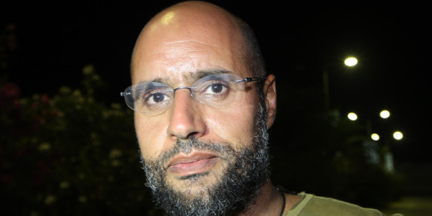 Saif al-Islam Kadhafi, son of Libyan leader Moamer Kadhafi, appears in front of supporters and journalists at his father's residential complex in the Libyan capital Tripoli in the early hours of August 23, 2011. Seif al-Islam, wanted by the International Criminal Court for crimes against humanity and who ICC prosecutor Luis Moreno-Ocampo earlier said had been arrested by the rebels, claimed the insurgents had suffered 'heavy casualties' when they stormed Kadhafi's Bab al-Azizya compound in Tripo
