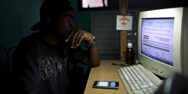 Informatics technician Yurkel Medina, 36, studies about new technologies at the mobile phone repair shop where he works in downtown Havana, February 23, 2016. REUTERS/Alexandre Meneghini