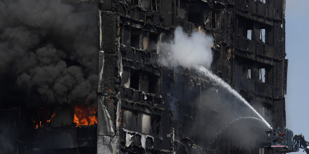 Firefighters direct jets of water onto a tower block severely damaged by a serious fire, in north Kensington, West London, Britain June 14, 2017. REUTERS/Toby Melville
