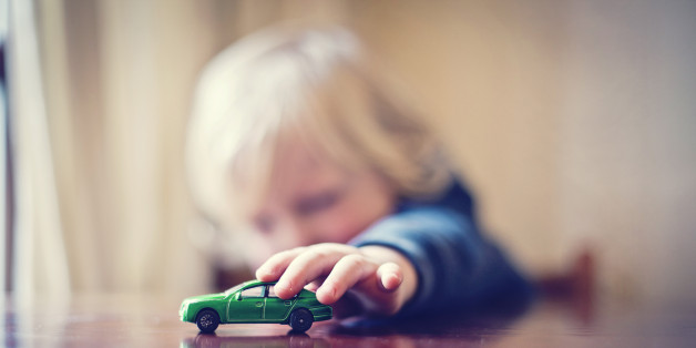 Little boy playing with toy car.