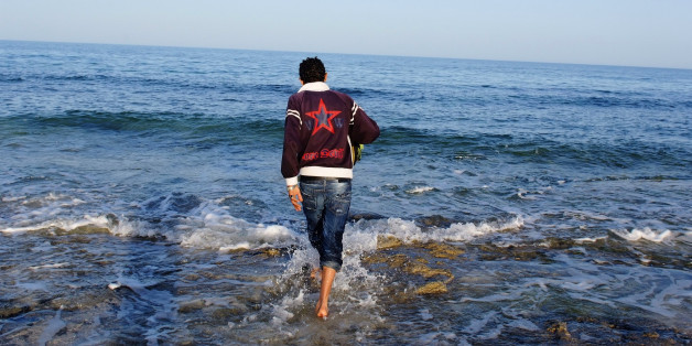 A Tunisian man, who considered illegal migration to Europe, walks at the water's edge at coastal town Zarzis in southeastern Tunisia February 18, 2011. Tunisia has deployed soldiers to stop a tide of illegal immigrants trying to reach Italy, a military source said Monday, after Rome said a revolution in the north African country had set off a "biblical exodus." REUTERS/Anis Mili (TUNISIA - Tags: POLITICS SOCIETY)