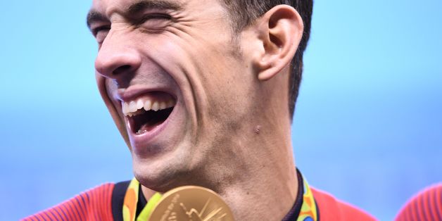TOPSHOT - USA's Michael Phelps poses with his gold medal during the podium ceremony of the Men's swimming 4 x 100m Medley Relay Final at the Rio 2016 Olympic Games at the Olympic Aquatics Stadium in Rio de Janeiro on August 13, 2016. Michael Phelps brought down the curtain on his glittering Olympic career when he helped the USA win 4x100m medley relay gold at the Rio Games on Saturday, taking his personal tally to 23. / AFP / GABRIEL BOUYS (Photo credit should read GABRIEL BOUYS/AFP/Gett