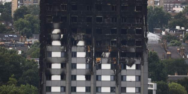 Unburned lower floors with untouched cladding in place are seen with the burnt out upper floors of the Grenfell Tower block in North Kensington, west London, on June 18, 2017. The presumed death toll from the London tower block inferno jumped to 58 on Saturday as embattled Prime Minister Theresa May, accused of misreading the growing anger over the tragedy, pledged action after meeting survivors desperately seeking answers. / AFP PHOTO / Tolga AKMEN (Photo credit should read TOLGA AKMEN/A