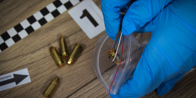 Forensic experts collects evidence from the crime scene. Bullets packed in a bag with a pair of tweezers