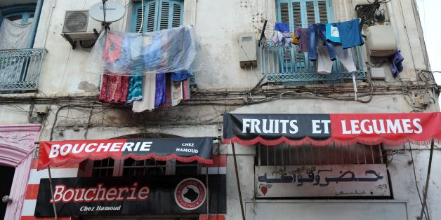 Clothes hang above shops bearing the colours of the Union Sportive Medina d'Alger (USMA) football club in the Soustara neighbourhood in the old part of Algiers known as the 'Casbah', which is historically known to be predominantly supporting USMA, in Algiers on October 11, 2016, two days ahead of the 100th derby match against their rival Mouloudia Club d'Alger (MCA).
MC Alger and USM Alger may be fierce city rivals from the Algerian capital but they nonetheless share a history intwined with their country's revolt against French colonialism. / AFP / Ryad Kramdi / TO GO WITH AFP STORY BY ABDELHAFID DAAMACHE (Photo credit should read RYAD KRAMDI/AFP/Getty Images)
