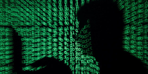 A man holds a laptop computer as cyber code is projected on him in this illustration picture taken on May 13, 2017. Capitalizing on spying tools believed to have been developed by the U.S. National Security Agency, hackers staged a cyber assault with a self-spreading malware that has infected tens of thousands of computers in nearly 100 countries. REUTERS/Kacper Pempel/Illustration