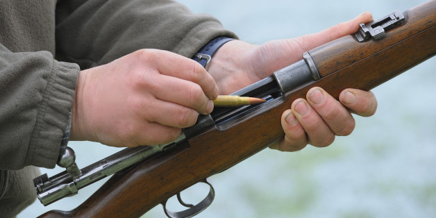 Close-up of a hunter loading his rifle.