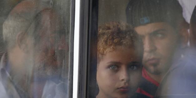 A rescued migrant child looks out of the window of a police bus after arriving at the Armed Forces of Malta Maritime Squadron base at Haywharf in Valletta's Marsamxett Harbour October 12, 2013. Dozens of people died on Friday when a boat carrying around 250 migrants capsized between Sicily and Tunisia, in the second such shipwreck this month, the Italian coastguard said. 147 survivors, believed to all be Syrians, arrived in Malta on Saturday morning, according to local media.
REUTERS/Darrin Zammit Lupi (MALTA - Tags: SOCIETY IMMIGRATION DISASTER) MALTA OUT. NO COMMERCIAL OR EDITORIAL SALES IN MALTA