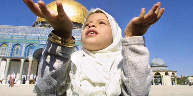 A Muslim Palestinian girl prays in front of the Dome of the Rock in the Al-Aqsa mosque compound in the Old city of Jerusalem for the first Friday of the holy month of Ramadan 08 November 2002. only one person was arrested through out the morning, an Israeli Jew wearing a traditional chequered Palestinian head dress, who tried to get into the compound passing as a Muslim. More than 2,000 police were deployed through out the city to prevent possible violence. Unlike the recent past, there was no a