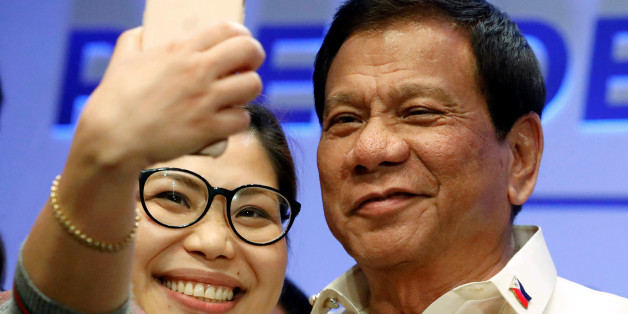 A journalist takes a selfie with Philippine President Rodrigo Duterte after a news conference in Manila, Philippines April 29, 2017. REUTERS/Erik De Castro