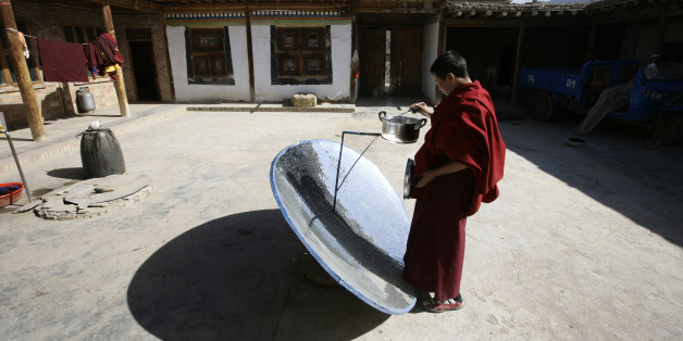 Ein Mönch in Tongren, Qinghai kocht sein Mittagessen auf einem solarbetriebenen Ofen