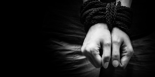Hands of a missing kidnapped, abused, hostage, victim woman tied up with rope in emotional stress and pain, afraid, restricted, trapped, call for help, struggle, terrified, locked in a cage cell.