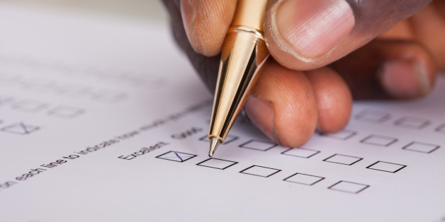 Close-up Of Businessman Filling Customer Survey Form